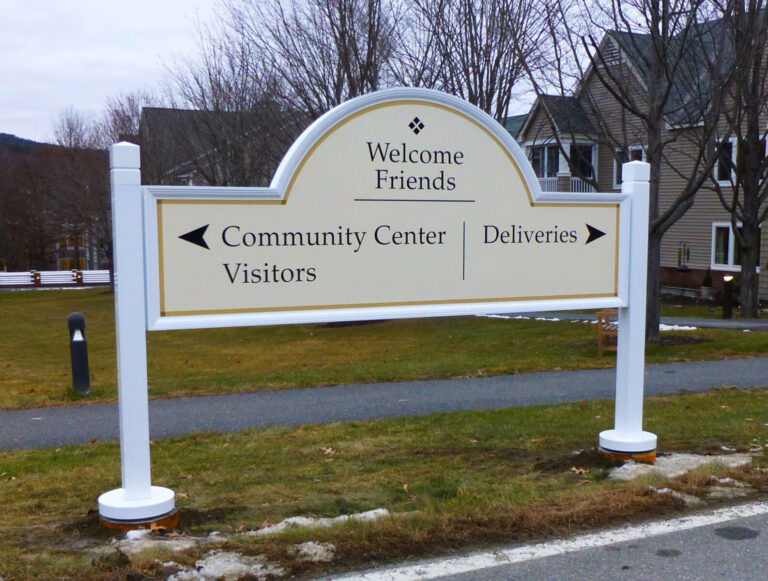 Kendal B Directional Signage White outdoor sign reads "Welcome Friends" with arrows for Community Center Visitors (left) and Deliveries (right).