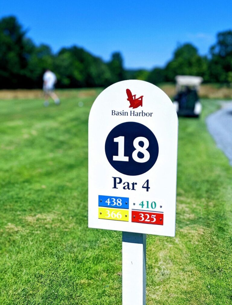 Basin Harbor Golf Course Marker White golf hole marker sign for hole 18, Par 4, at Basin Harbor with yardages listed for four tee positions.