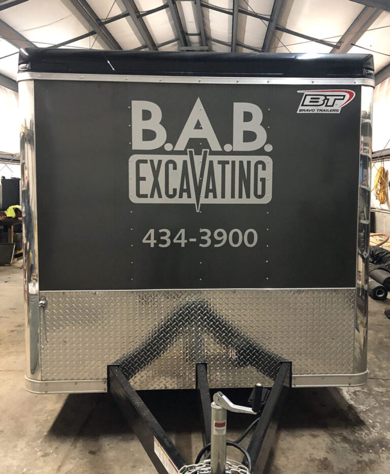 BAB Excavating Front of a gray trailer with "B.A.B. Excavating" and the phone number 434-3900 printed on it.