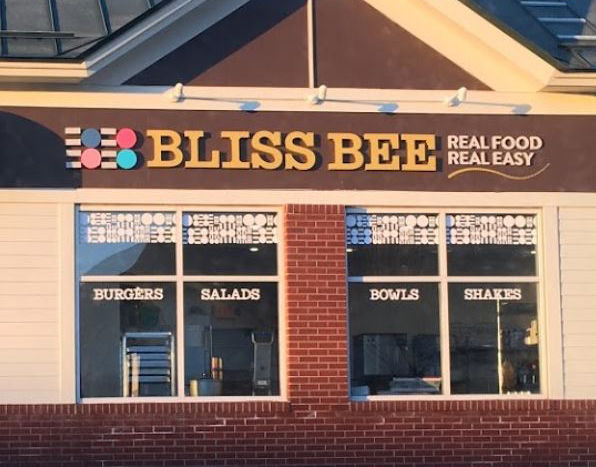 Bliss Bee Window & Building Bliss Bee restaurant exterior with signage advertising burgers, salads, bowls, and shakes.