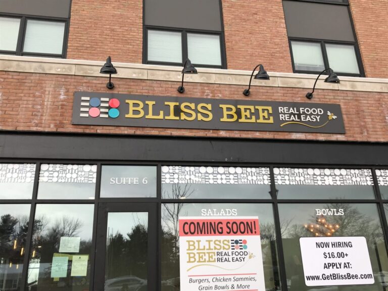 Bliss Bee Exterior Front Storefront of Bliss Bee restaurant with "Coming Soon!" and "Now Hiring" signs displayed on the window.