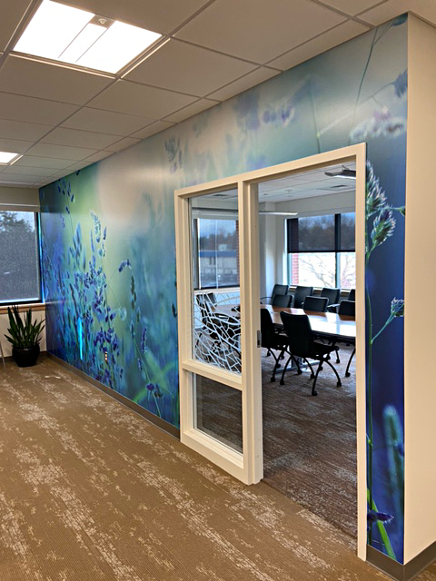 Large Format Digital Printed Wall Office hallway with a nature-themed wall mural, a door with glass panel, and a conference room visible through the doorway.