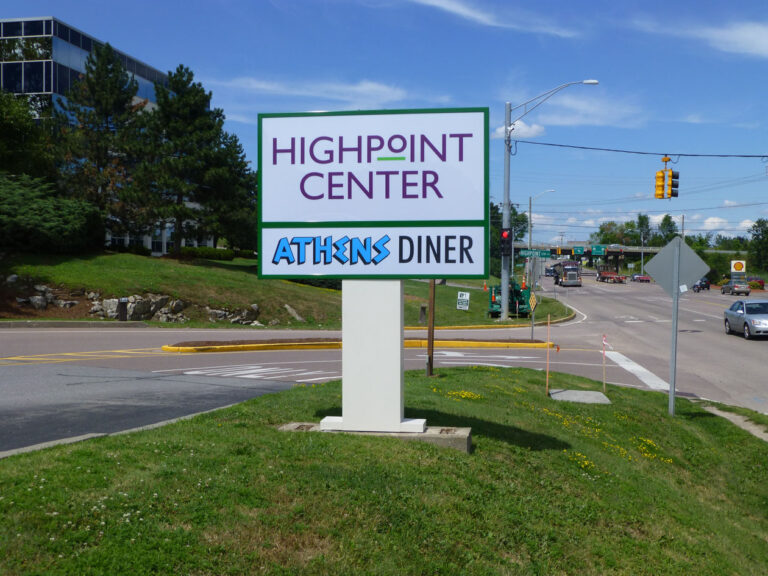 Electric Highpoint Center A roadside sign reads "Highpoint Center" and "Athens Diner" near a busy intersection and office building.