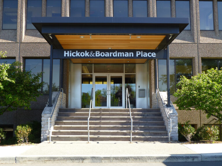 Hickok & Boardman Place Entrance to Hickok & Boardman Place with stairs, glass doors, and trees on either side of the building.