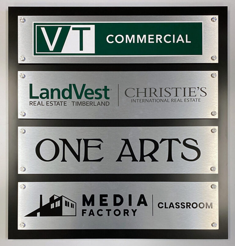 Custom Building Directory A wall sign displays VT Commercial, LandVest Christie's, One Arts, and Media Factory Classroom on metallic plates.