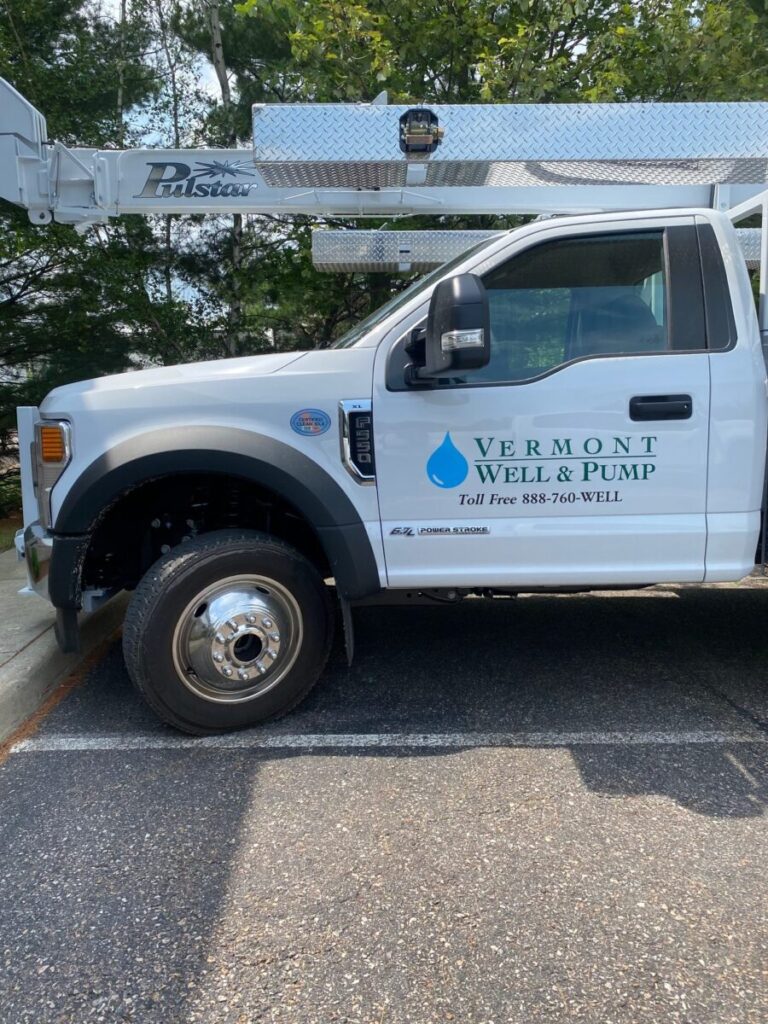 Vehicle Graphics White Vermont Well & Pump service truck parked in a lot, with company logo and phone number visible on the door.