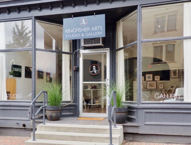 Kingfisher Arts Studio Storefront of Kingfisher Arts Studio & Gallery with glass windows, potted plants, and art displayed inside.