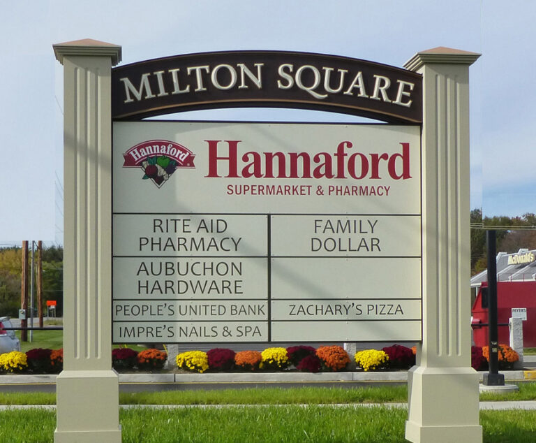Milton Square A sign for Milton Square lists businesses including Hannaford, Rite Aid Pharmacy, and Family Dollar, with flowers at the base.