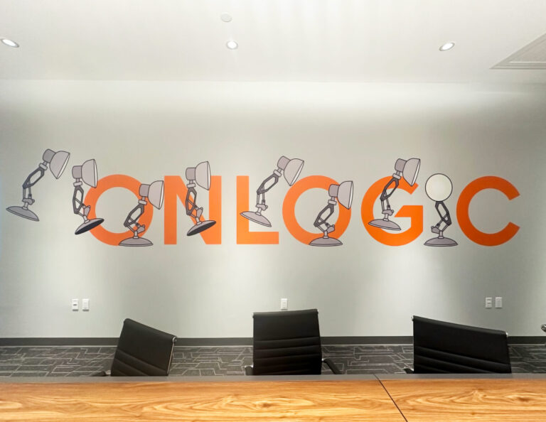 Onlogic Vinyl Wall Graphic Conference room wall with orange text "ONLOGC" and drawings of desk lamps interacting with the letters.