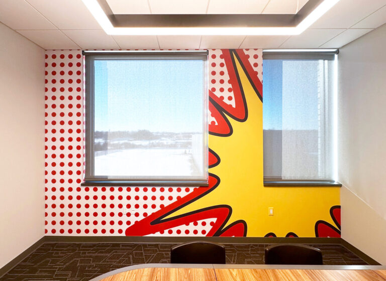 Onlogic Digital Printed Wall Graphic A meeting room with two large windows and a wall painted with a bold red and yellow pop art design.