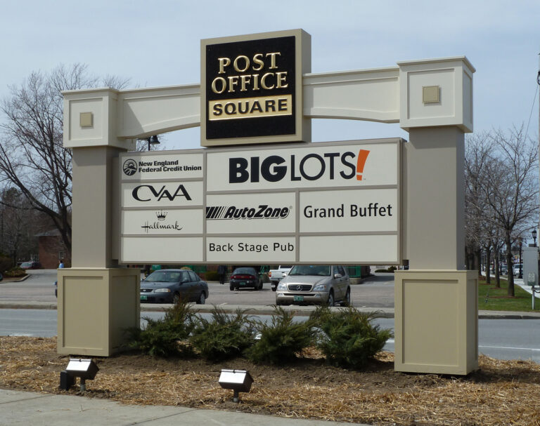 Post Office Square Exterior Outdoor sign listing businesses at Post Office Square, including Big Lots, AutoZone, and several others, by a parking lot.