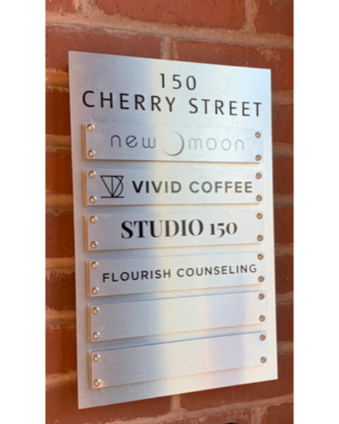 150 Cherry Street Directory A metal directory sign lists four businesses at 150 Cherry Street, mounted on a brick wall.