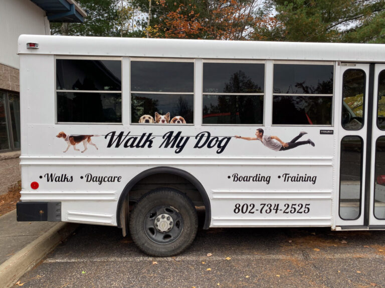 Walk My Dog Bus White bus advertises "Walk My Dog" with images of dogs pulling a person, and lists walks, daycare, boarding, and training.