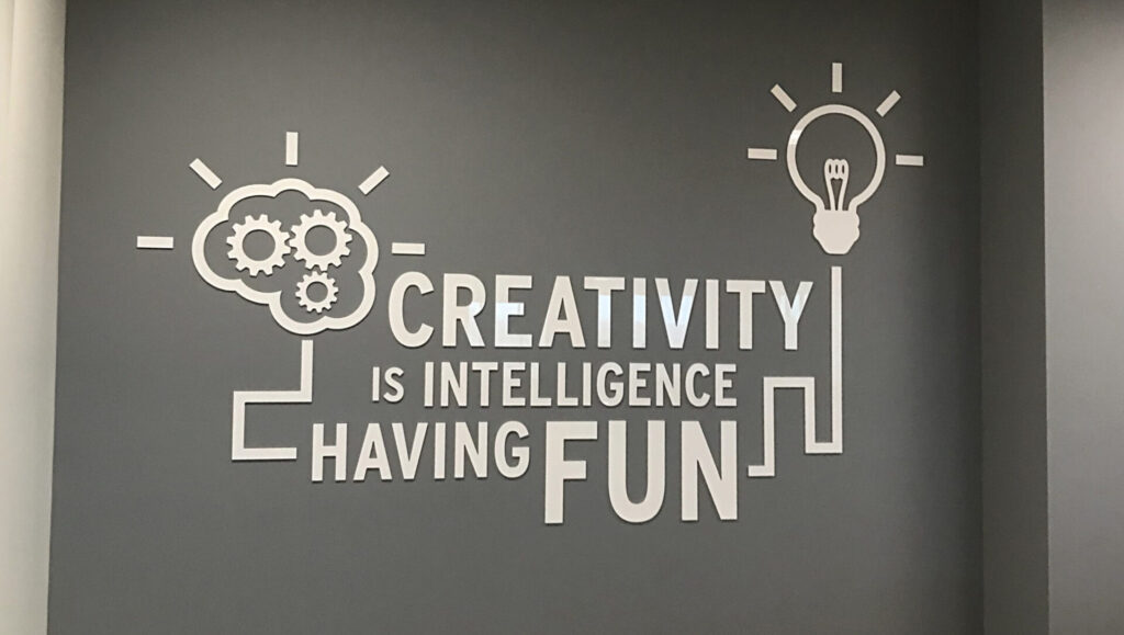 Raised 3 Dimensional Wall Graphic Wall art with gears, a brain, a lightbulb, and the quote: "Creativity is intelligence having fun.